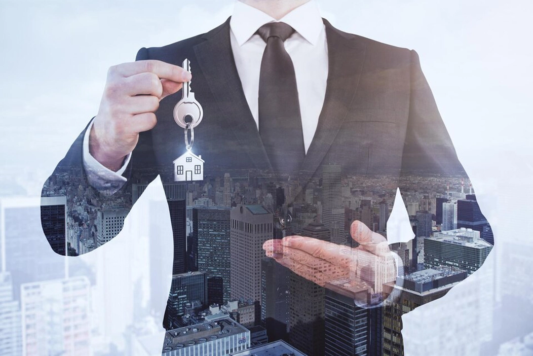 guy holding key and showing dubai area with buildings and properties in background